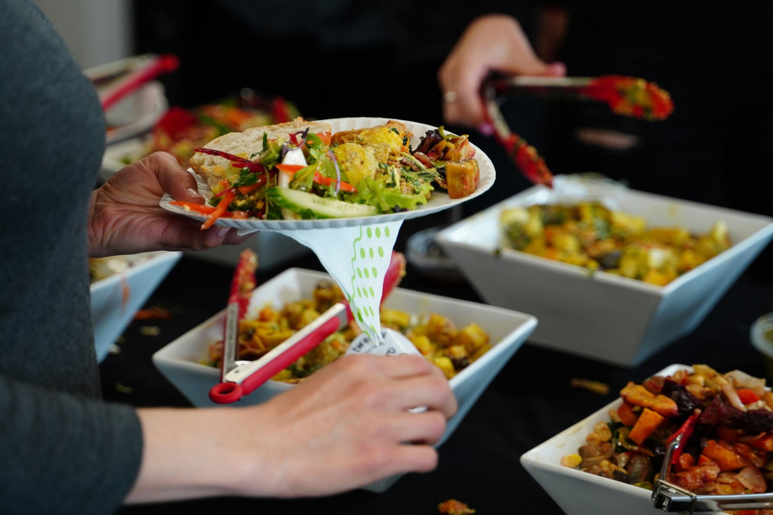 Person serving buffet food for sustainable and low-waste event and conference consulting