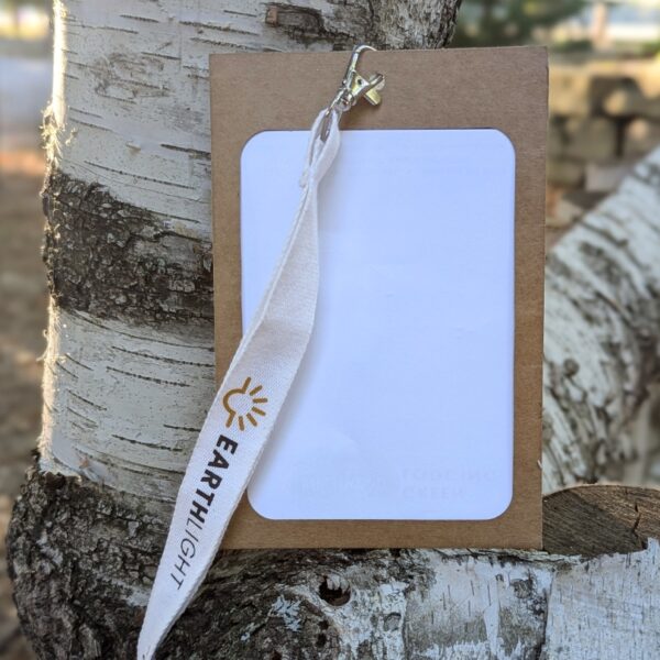 Outdoor view of sustainable, paper conference, meeting and event name badge holder with branded, organic cotton lanyard with lobster claw.