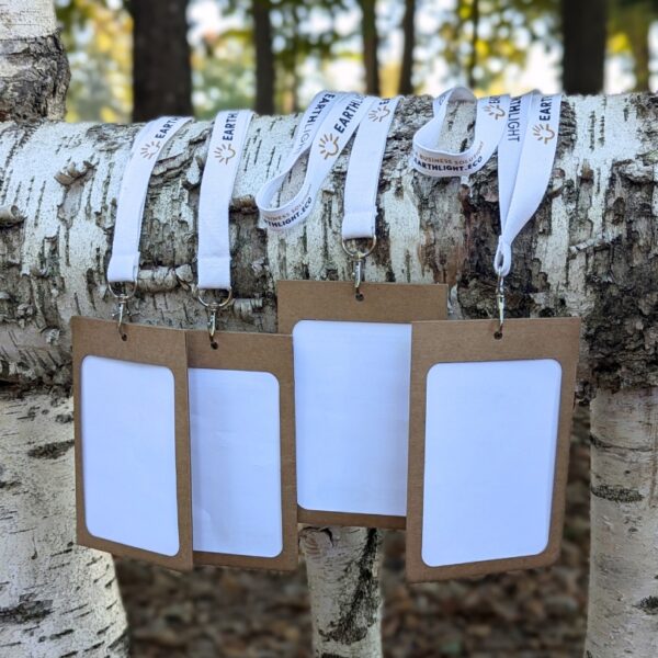 View of four paper, eco-friendly name badge holders with branded, organic cotton lanyards for sustainable meetings, conferences and events.