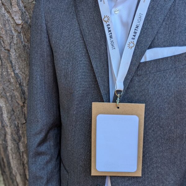 Man in suit wearing eco-friendly paper conference, meeting and event name badge holder with organic cotton lanyard